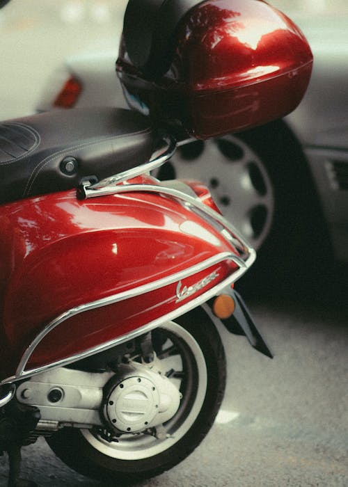 Turista con casco conduciendo Vespa