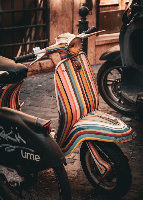 Conductor revisando Vespa antes de iniciar ruta en Roma